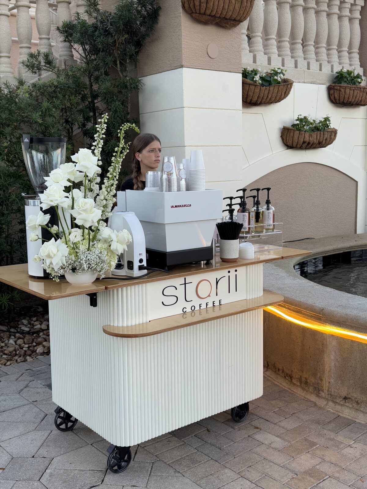 Storii cart styled with white florals at a resort courtyard event