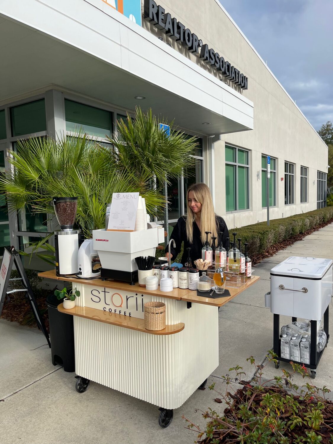 Storii Coffee barista serving from the fluted mobile cart at a daytime corporate event