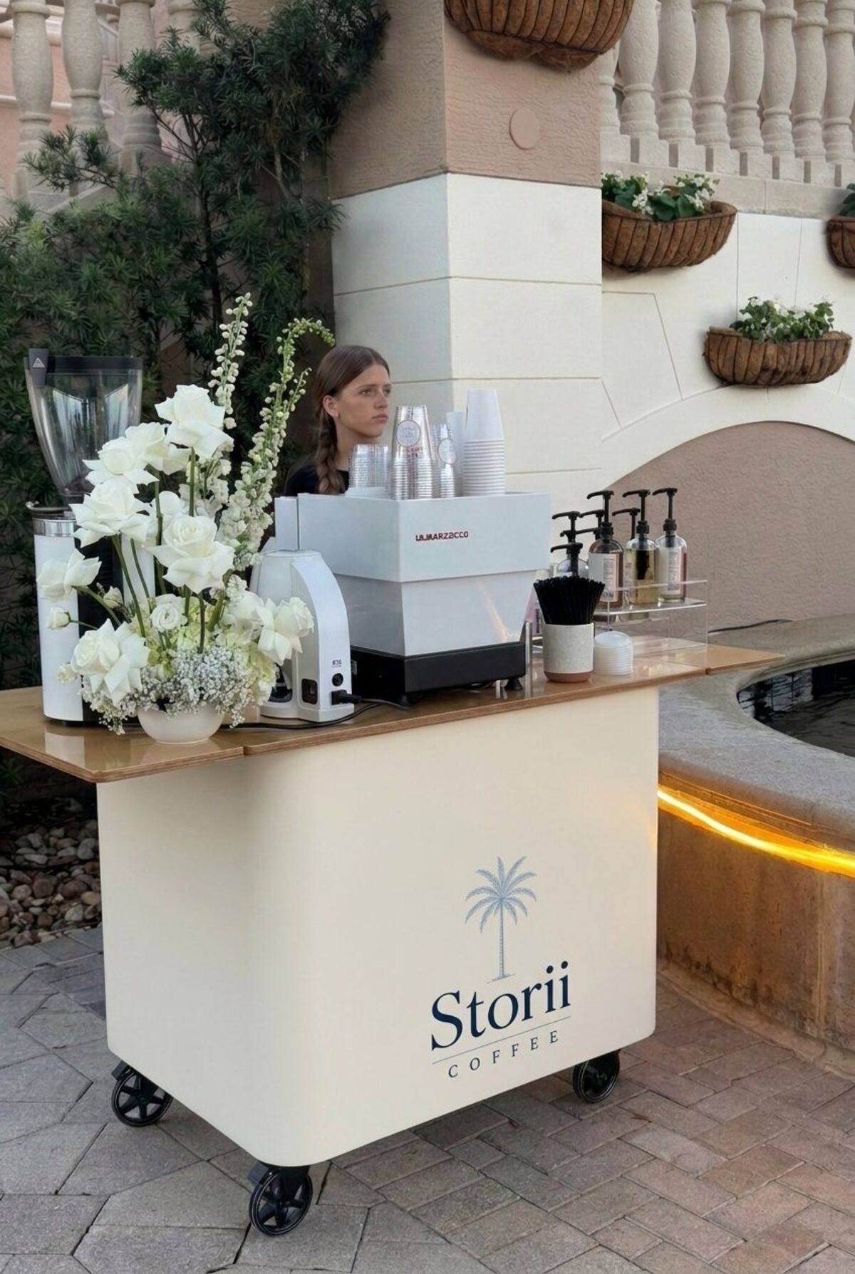Storii Coffee cream espresso cart styled with white florals at a poolside Florida event