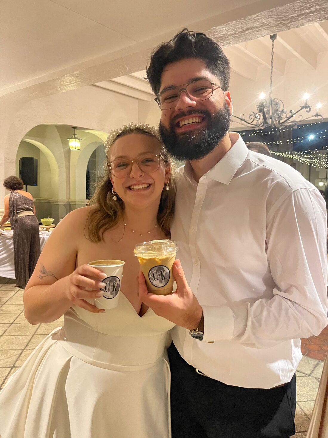 Newlyweds smiling with their Storii Coffee drinks at the reception